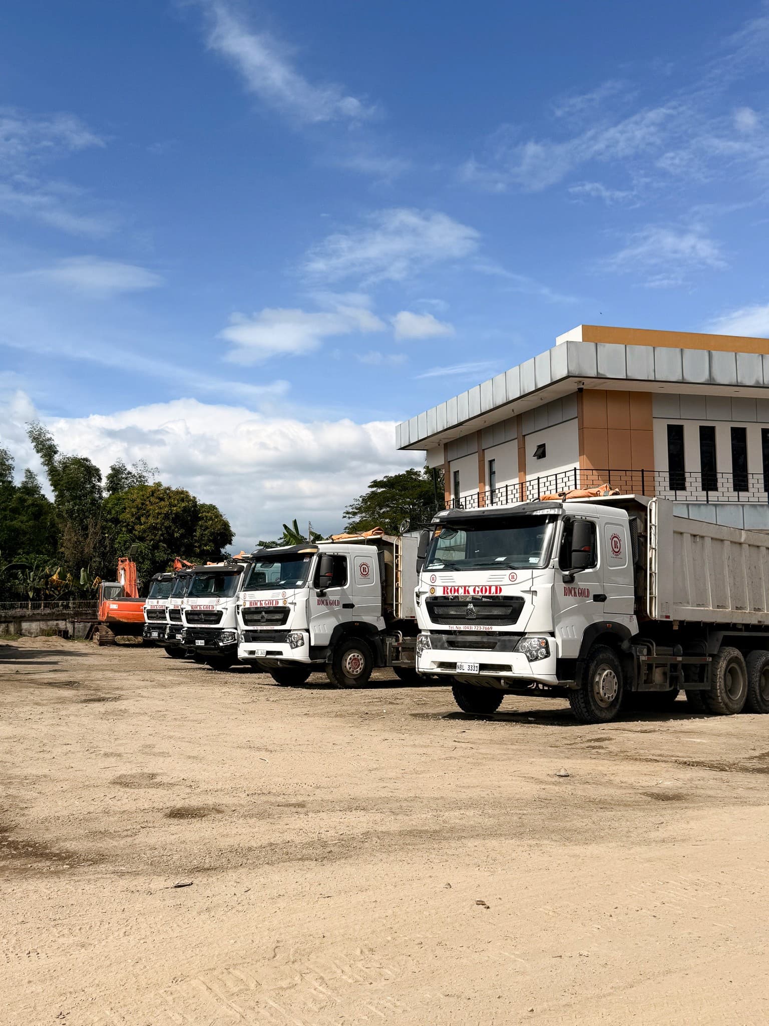 A row of Rock Gold dump trucks at the company yard